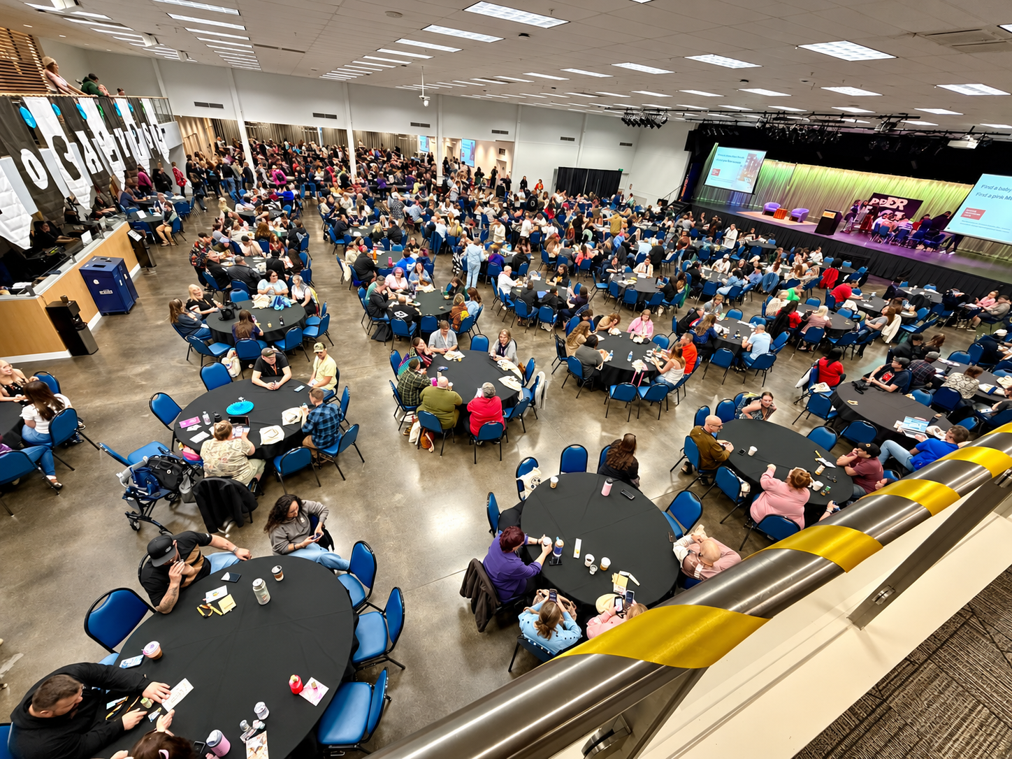 Audience seated at tables in a large event hall