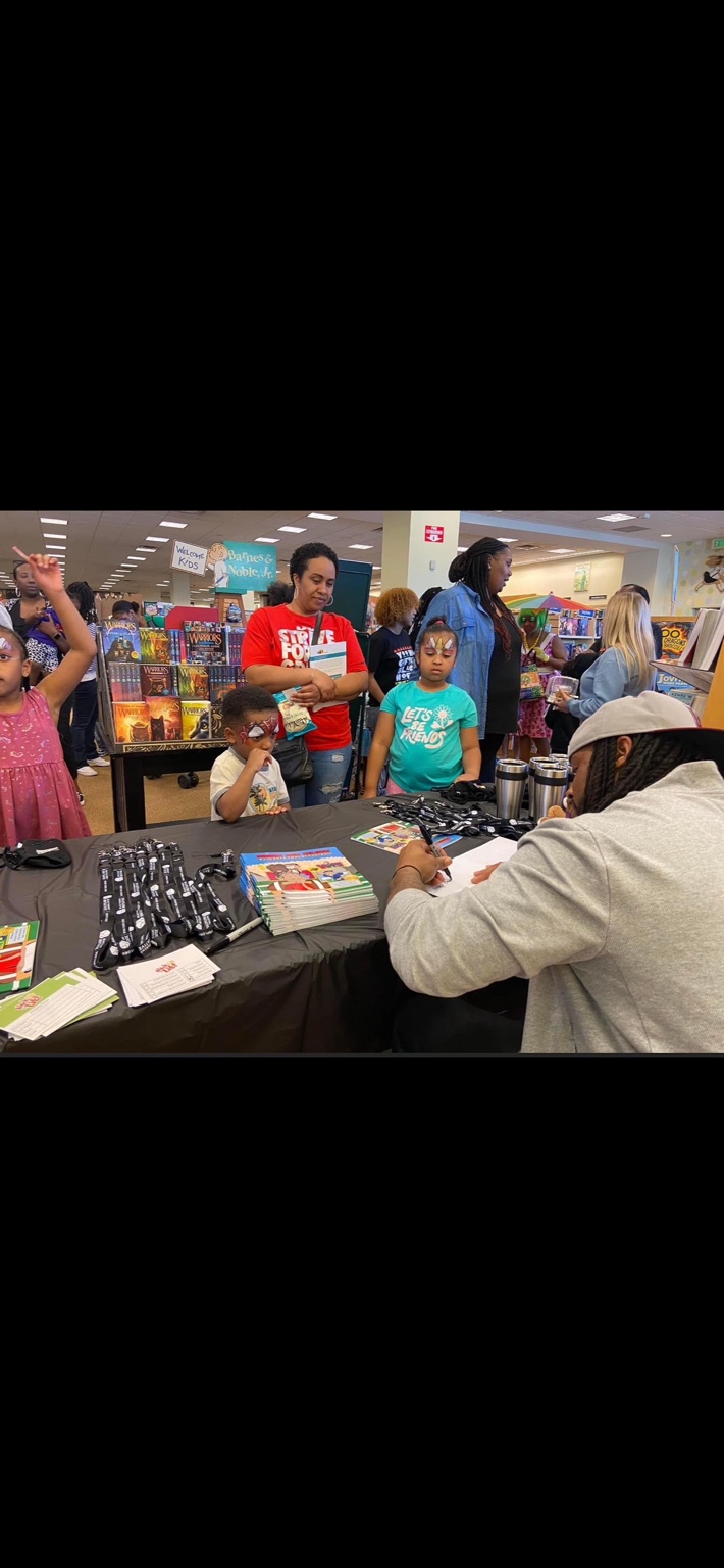 Alex Green signing books for children and families at a bookstore