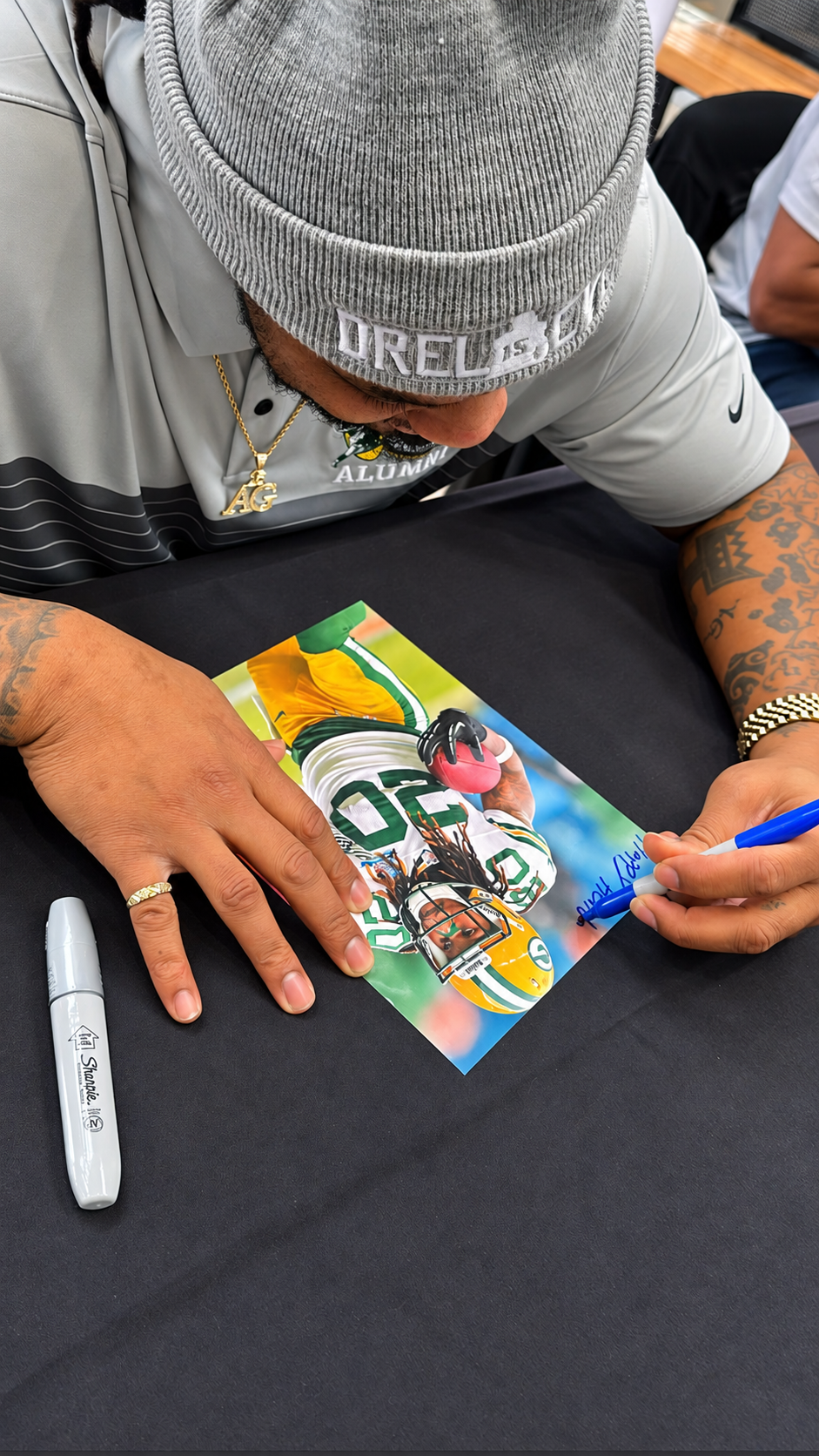 Alex Green signing a football photograph