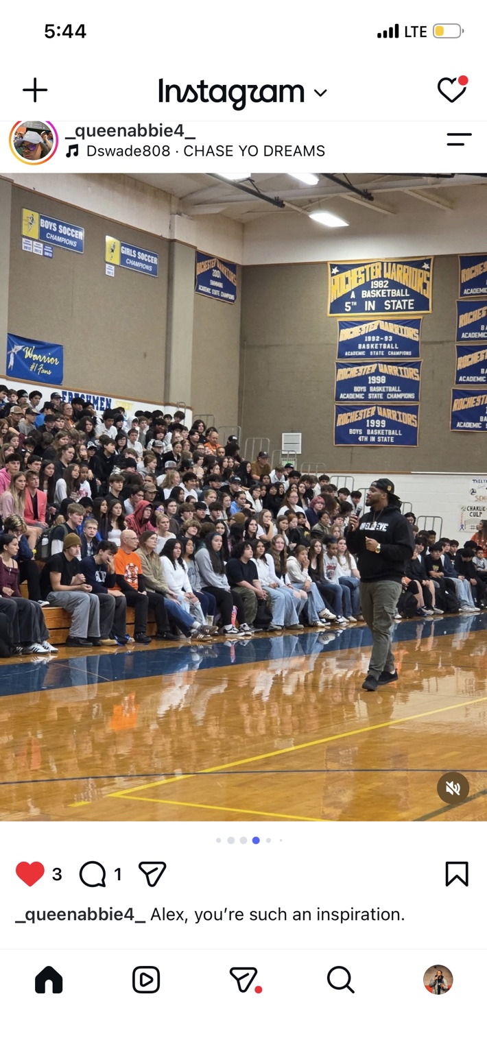 Alex Green speaking to students in a packed school gym